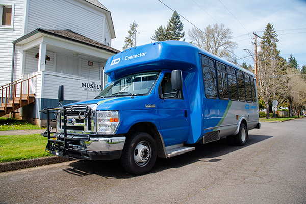 A blue and white public transit shuttle bus labeled 