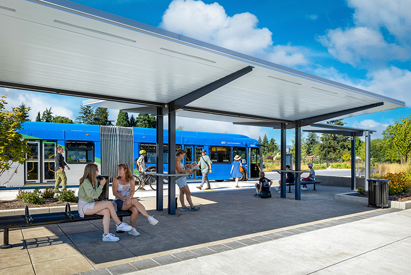 Riders at Santa Clara Station wait to board the bus in the shade.