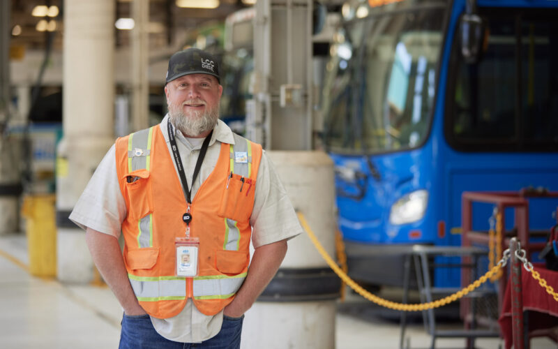 employee standing in front of bus